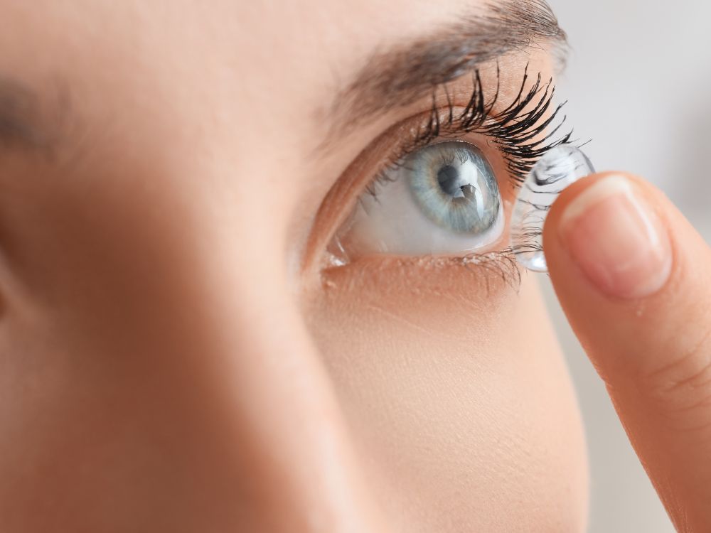 Close no olho com lente de contato sendo aplicada, mostrando detalhes e explicando quem pode usar lente de contato com grau com segurança.