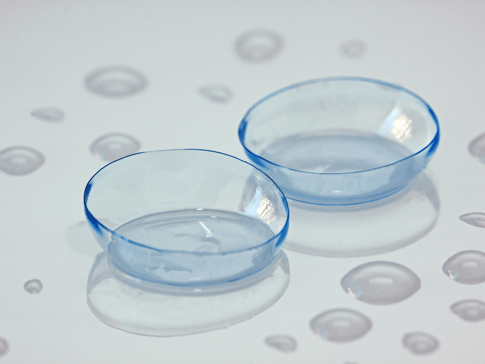 Duas lentes de contato armazenadas com solução apropriada, evidenciando a importância da hidratação e limpeza.